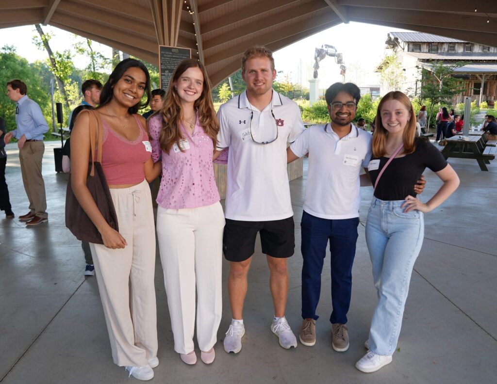 Young professionals pose for a photo at a social event